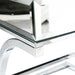 Up-close view of surface corner of contemporary glam chrome finish steel and mirror table.