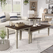 Semi-side facing view of transitional three-piece antique white and brown finish wood coffee table set in living room with accessories