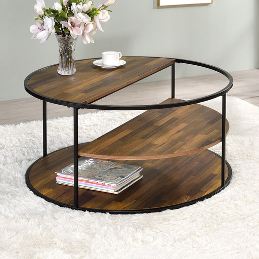 Semi-side facing view of contemporary round black finish steel and wood three-level coffee table in a living room with accessories