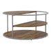Angled view of contemporary round gray finish steel and wood three-level coffee table on a white background