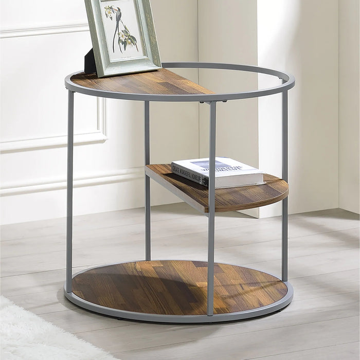 Angled view of contemporary round gray steel and wood three-level end table in a living room with accessories