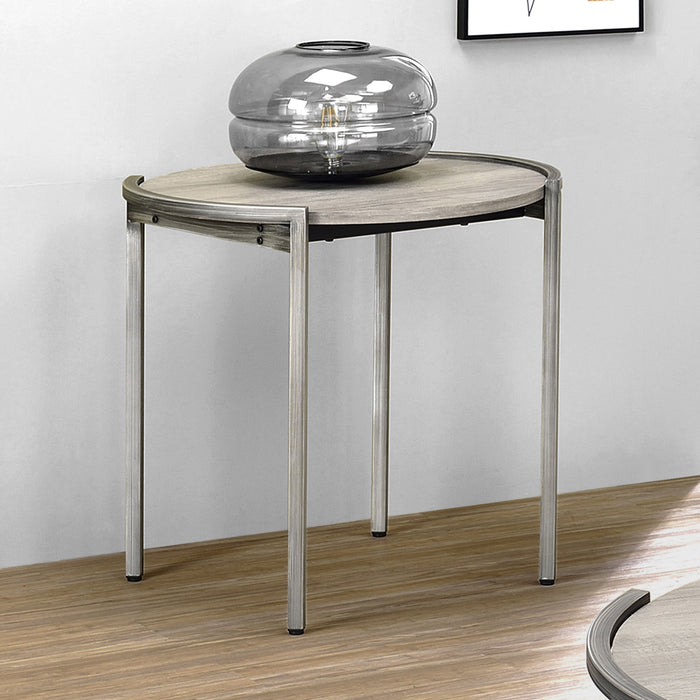 Left angled elevated view of contemporary light gray and gunmetal round end table in a living room with accessories.