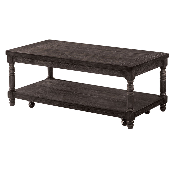 Left angled contemporary gray wood coffee table on a white background. Carved legs, open bottom shelf, and wood plank tabletops offer rustic touch.