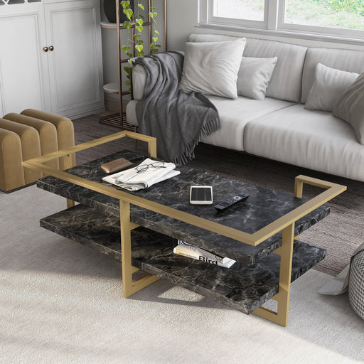 Left angled contemporary gold steel coffee table in front of a sofa in a living room setting. Black faux marble tabletops set in slender gold railing offer glam look and ample storage space.