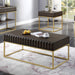 Left angled contemporary walnut gold coffee table and end table with decorative accessories in a living room setting. Slim gold steel base and geometric texture wood drawer fronts offer extra attention to detail.