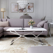 Front-facing glam chrome and white geometric coffee table in a living room with accessories