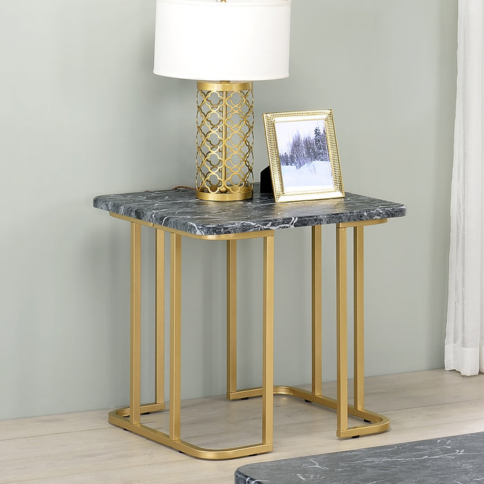 Angled view of contemporary black marble and gold coated steel geometric end table in a living room with accessories