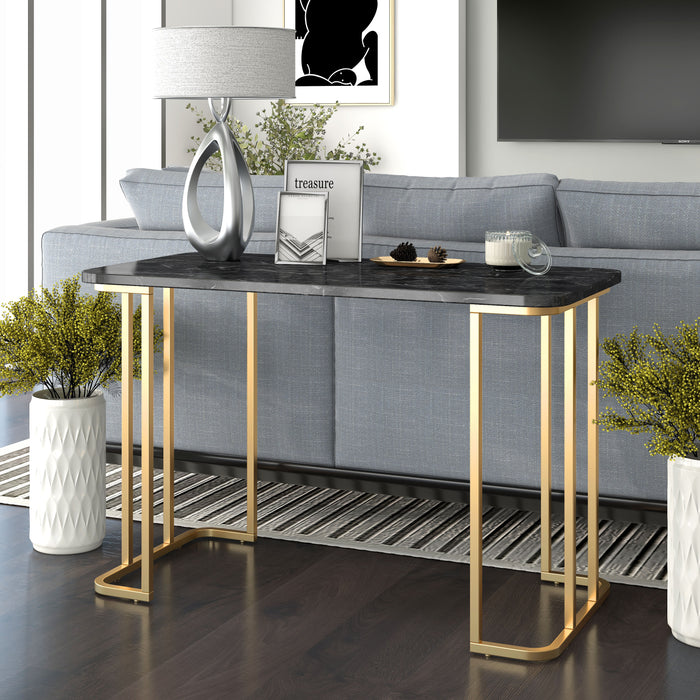 Angled view of contemporary black marble and gold coated steel geometric sofa table in a living room with furnishings and accessories