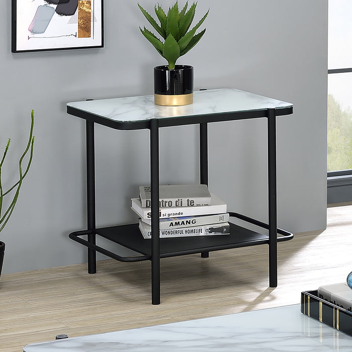 Right angled modern industrial black steel end table with tempered white marble glass top, slender steel legs and perforated open metal shelf decorated with plant and books against a wall.