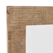 Close-up partial view of artistic detail on natural finish mango wood framed rectangular decorative mirror on white background