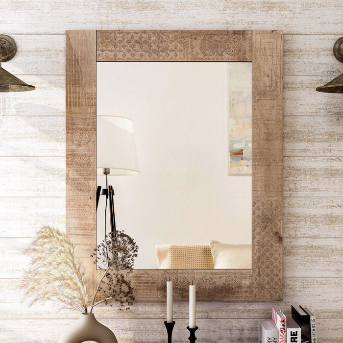 Front-facing view of natural finish mango wood framed rectangular decorative mirror in living space with accessories