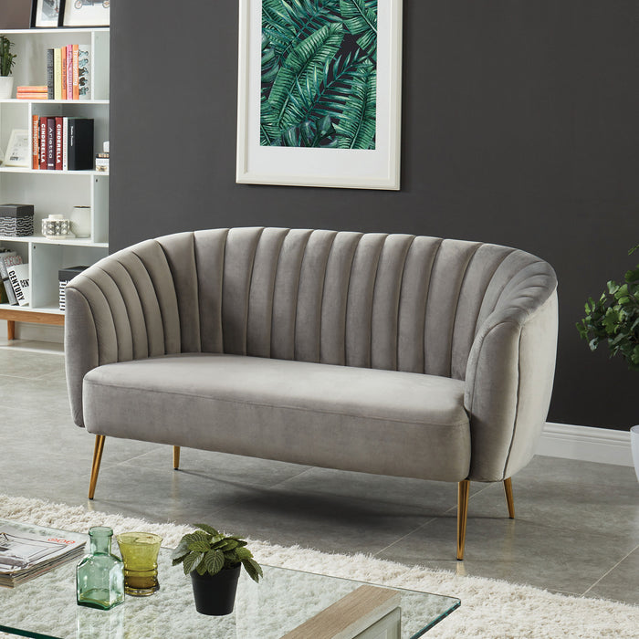 Left-angled modern glam shell tufted loveseat with light gray upholstery and gold finish legs in a contemporary living room with accessories