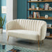 Left-angled modern glam shell tufted loveseat with ivory upholstery and gold finish legs in a contemporary living room with accessories