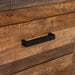 Right angled close up drawer front detail from a rustic natural mango wood five-drawer accent chest