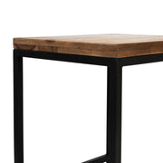 Partial angled view of rustic natural tone wood and black steel industrial bar stool on white background