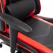 Angled partial view of contemporary red and black faux leather and metal gaming chair on a white background