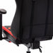 Angled back-facing partial view of mid-section of contemporary red and black faux leather and metal gaming chair on white background