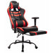 Angled view of contemporary red and black faux leather and metal gaming chair with footrest extended on a white background