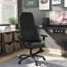 Right angled race car-inspired black and light blue faux leather gaming chair at a desk with accessories