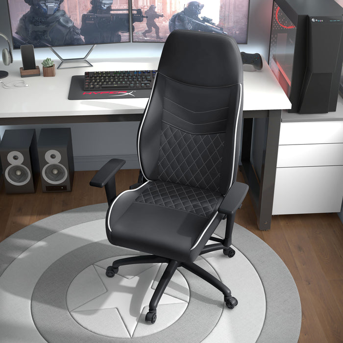 Angled, elevated view of modern black and white faux leather and strong iron adjustable gaming chair in work space with furnishings and accessories