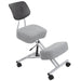 Right angled modern light gray ergonomic kneeling chair with wheels on a white background