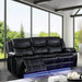 Right facing transitional black faux leather power recliner sofa with contrast stitching and LED lighting in a living room with accessories and matching loveseat
