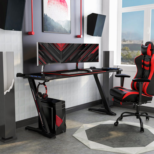 Right angled contemporary black gaming desk with red accents in a living space with accessories