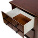 Detail shot of the top drawer of a traditional cherry nightstand against a white background. The top drawer features a four-panel knob design and felt-lining.