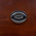 Detail shot of a bronze bail ring pull on a traditional cherry nightstand. 