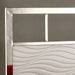 Right-angled close up modern glam white and chrome bed headboard detail against a gray bedroom wall