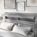 Left-angled close-up of the hidden storage headboard on a modern glam gray upholstered bed in a stylish bedroom with accessories