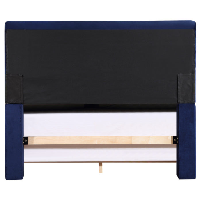 Front-facing back view of a modern glam navy blue upholstered bed on a white background