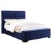 Right-angled modern glam navy blue upholstered bed with linens on a white background