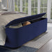 Right-angled close-up of the storage footboard on a modern glam navy blue upholstered bed in a stylish bedroom with accessories