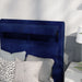 Left-angled close-up of the hidden storage headboard on a modern glam navy blue upholstered bed in a stylish bedroom 