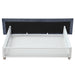 Front-facing back view of the underbed drawer of a modern glam gray upholstered bed on a white background