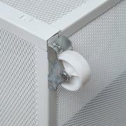 Close-up view of the wheel on an underbed drawer of a modern glam gray upholstered bed