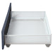 Front-facing side view of the underbed drawer of a modern glam gray upholstered storage bed on a white background