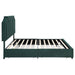 Front-facing side view of a modern glam dark green upholstered storage bed with nailhead trim with no mattress on a white background