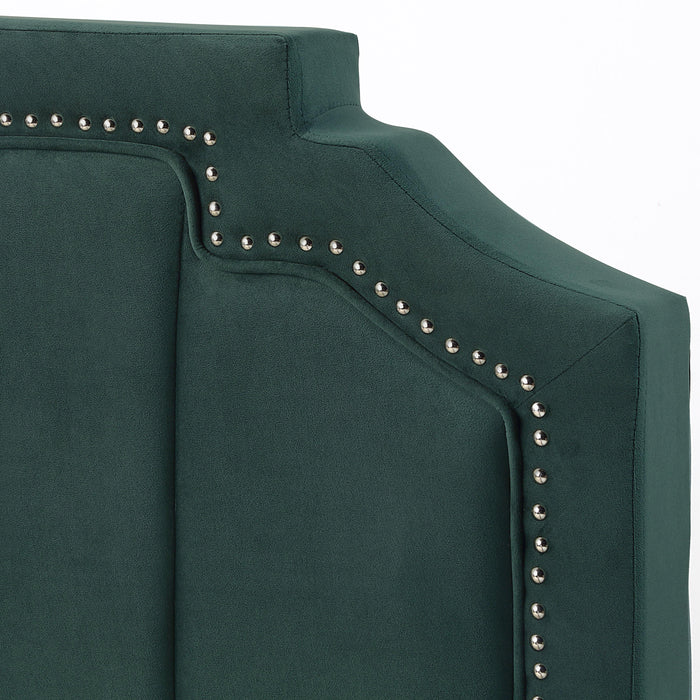 Left-angled close up view of the headboard on a modern glam dark green upholstered storage bed with nailhead trim and underbed storage drawers on a white background