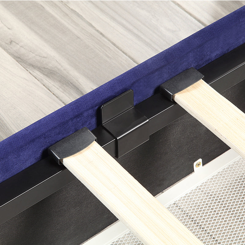 Left-angled close-up frame and underbed drawer detail view of a modern glam navy blue upholstered storage bed with nailhead trim on a woodgrain floor