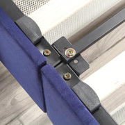 Left-angled close-up frame and underbed drawer detail view of a modern glam navy blue upholstered storage bed with nailhead trim on a woodgrain floor