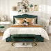 Front-facing modern glam dark green upholstered storage bed with panel-style nailhead trim and underbed drawers in a stylish bedroom with linens and accessories