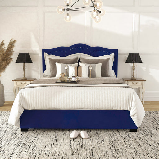 Front-facing modern glam navy blue upholstered storage bed with panel-style nailhead trim and underbed drawers in a stylish bedroom with linens and accessories