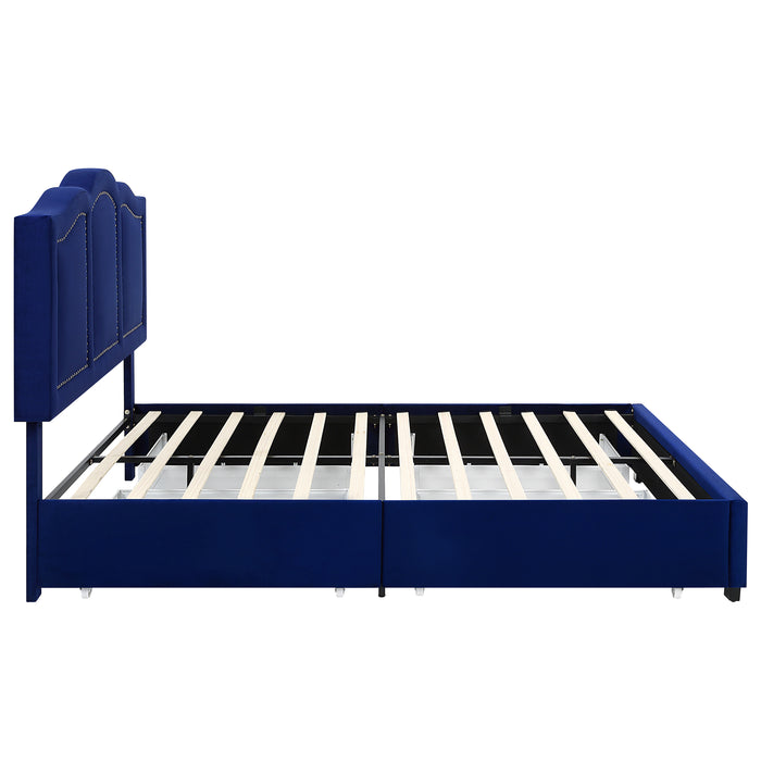 Front-facing side view of a modern glam navy blue upholstered storage bed with panel-style nailhead trim and underbed drawers on a white background