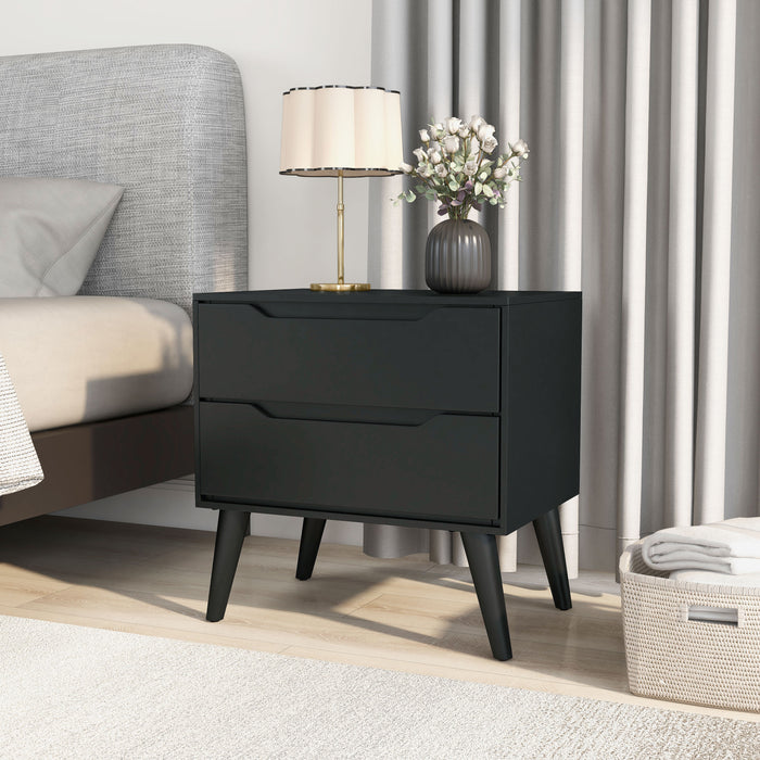 Left-angled black finished mid-century modern style nightstand in a modern and moody bedroom. Next to an upholstered bed with a hint of mint, the glass-sea blue vase of the table lamp mixes well with the decorative mini Christmas trees and Eden green velvet pillow and comforter.