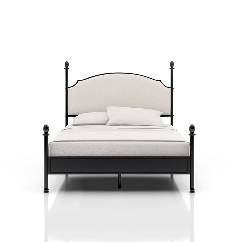 Right-angled California King-sized four-poster bed sits against a white background. The camelback is a beige upholstery while the frame of the bed is a gunmetal finish with slender posts that present ball finials.