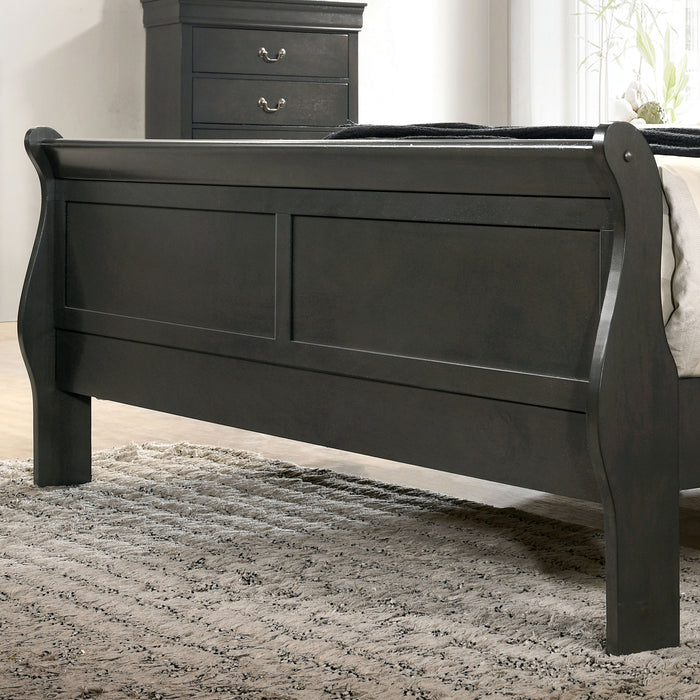 Left-angled close-up of the footboard on a transitional gray finish wooden sleigh bed in a stylish bedroom with linens and accessories