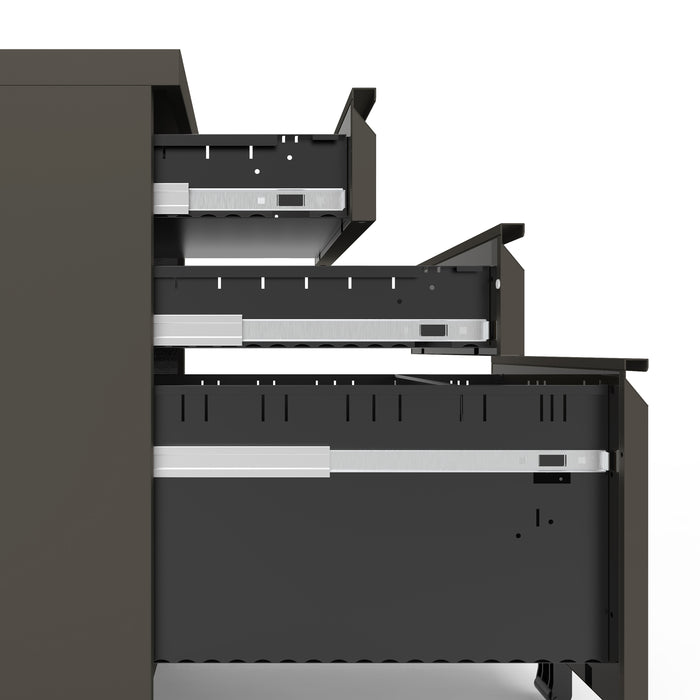 Front facing side view of a contemporary three-drawer gunmetal locking file cabinet with wheels and drawers open on a white background