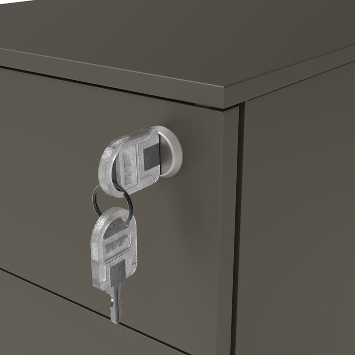 Left angled close up lock and key detail of a contemporary three-drawer gunmetal locking file cabinet with wheels